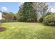 Large grassy backyard enclosed by a wooden fence and mature trees, perfect for outdoor activities at 2310 Nutting Ln, Apex, NC 27523