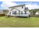 White home exterior with a back deck, green lawn, and mature trees providing shade and privacy at 2310 Nutting Ln, Apex, NC 27523