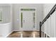 Bright foyer featuring hardwood floors, a staircase, and a front door with sidelights at 2310 Nutting Ln, Apex, NC 27523
