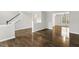 Open floor plan living room area featuring hardwood floors, and a view of the staircase and foyer at 2310 Nutting Ln, Apex, NC 27523