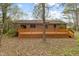 Back exterior of brick home with a large deck with wood railings at 251 W Moffitt Avenue, Liberty, NC 27298