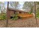 Rear exterior of brick house featuring a wooden deck and landscaped yard at 251 W Moffitt Avenue, Liberty, NC 27298