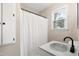Bathroom with white shower curtain, round sink, and a bright window at 251 W Moffitt Avenue, Liberty, NC 27298