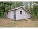 Exterior view of backyard outbuilding with a ramp and white trim at 251 W Moffitt Avenue, Liberty, NC 27298