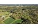 Aerial view showcases the property lines amid a dense forest and adjacent green fields at 2603 Brogden Rd, Creedmoor, NC 27522