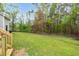 Backyard features a green lawn with a chainlink fence and a treeline at 2603 Brogden Rd, Creedmoor, NC 27522
