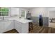 Bright eat-in kitchen with white cabinetry, light countertops, and modern flooring at 2603 Brogden Rd, Creedmoor, NC 27522