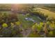 Scenic aerial view of a home with a pool surrounded by verdant trees and open fields at 2905 Glendale Rd, Kenly, NC 27542