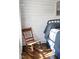 Relaxing bedroom area highlighted by wood floors, shiplap walls, rocking chair, and ample natural light at 2905 Glendale Rd, Kenly, NC 27542