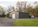 Spacious metal garage with a roll-up door and attached covered area sits on a gravel lot at 2905 Glendale Rd, Kenly, NC 27542