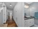 Open hallway with wood-look floors leading to a bathroom and other parts of the house at 2905 Glendale Rd, Kenly, NC 27542
