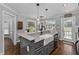 Elegant kitchen island with a farmhouse sink, granite counters and ample storage at 2905 Glendale Rd, Kenly, NC 27542