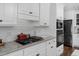 A well-lit kitchen features white cabinets, black hardware, and stainless steel appliances at 2905 Glendale Rd, Kenly, NC 27542