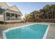 A lovely pool is surrounded by chairs, tables, fencing, and a screened-in porch for luxurious outdoor living at 2905 Glendale Rd, Kenly, NC 27542