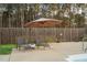 Inviting poolside area featuring comfortable lounge chairs, an umbrella, and a privacy fence for relaxation at 2905 Glendale Rd, Kenly, NC 27542