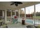 Relaxing screened porch featuring rocking chairs, string lights, and view of the fenced in pool area at 2905 Glendale Rd, Kenly, NC 27542