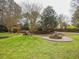 Expansive backyard with lush green lawn, a stone firepit, and ample space for outdoor activities at 2932 Candlehurst Ln, Raleigh, NC 27616