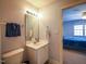 Clean bathroom featuring a single vanity, toilet, and a peek into an adjacent bedroom at 2932 Candlehurst Ln, Raleigh, NC 27616