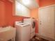 Functional laundry room with modern washer and dryer, storage cabinets, and sink at 2932 Candlehurst Ln, Raleigh, NC 27616