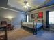 Large main bedroom with tray ceilings, a cozy sitting area, and natural light at 2932 Candlehurst Ln, Raleigh, NC 27616