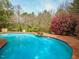 Inviting pool with rock waterfall feature and spacious deck, perfect for outdoor relaxation and entertaining at 2932 Candlehurst Ln, Raleigh, NC 27616