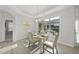 Sunlit dining room with large window, four upholstered chairs and modern chandelier at 301 Crayton Oak Dr, Cary, NC 27519