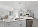 Well-lit kitchen island with stainless steel dishwasher and sink and an adjacent breakfast nook and living room at 301 Crayton Oak Dr, Cary, NC 27519