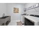 Clean laundry room with modern washer and dryer, stainless steel sink, and tiled flooring at 301 Crayton Oak Dr, Cary, NC 27519