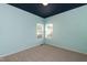 This bedroom features carpet, two windows that let in lots of light, and a deep blue painted ceiling at 3011 September Dr, Durham, NC 27703