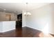 Elegant dining room adjacent to kitchen showcasing hardwood floors and a stylish chandelier at 3011 September Dr, Durham, NC 27703