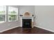 A fireplace with white mantle accents the living room with a window and hardwood flooring at 3011 September Dr, Durham, NC 27703