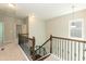 Upstairs hallway featuring metal railing and neutral color palette at 3011 September Dr, Durham, NC 27703