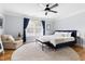 Bedroom featuring hardwood floors, a ceiling fan, and natural light from large windows at 303 N Guthrie Ave, Durham, NC 27703