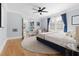 Bright bedroom featuring hardwood floors, a ceiling fan, and natural light from large windows at 303 N Guthrie Ave, Durham, NC 27703
