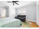 Bright bedroom with hardwood floors, fan, and a sitting area next to large window at 303 N Guthrie Ave, Durham, NC 27703
