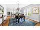 Open dining area with hardwood floors, modern chandelier and windows for natural light at 303 N Guthrie Ave, Durham, NC 27703