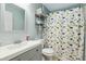 Bright bathroom with a single vanity, mirror and a colorful dinosaur shower curtain at 3050 Trailwood Pines Ln # 101, Raleigh, NC 27603