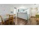 Open-concept living and dining area with a partial view of the kitchen, featuring hardwood floors at 3050 Trailwood Pines Ln # 101, Raleigh, NC 27603