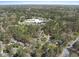 Wide aerial shot highlighting the community with a school and various homes nestled within a dense, green forest at 323 Brandermill Dr, Durham, NC 27713
