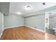 Open basement with hardwood flooring, neutral-colored walls, and a glimpse into a bathroom at 323 Brandermill Dr, Durham, NC 27713