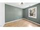 Bedroom with hardwood floors, a modern light fixture, and a window offering natural light at 323 Brandermill Dr, Durham, NC 27713
