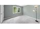 Bright bedroom featuring a large window offering a view of the surrounding greenery and soft, neutral carpet at 323 Brandermill Dr, Durham, NC 27713