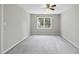 Neutral bedroom featuring ceiling fan and a large window at 323 Brandermill Dr, Durham, NC 27713