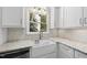 Bright kitchen with white cabinets, granite countertops, farmhouse sink, and white hexagon backsplash at 323 Brandermill Dr, Durham, NC 27713