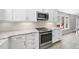 Kitchen featuring white cabinets, granite countertops, stainless steel appliances, and white hexagon backsplash at 323 Brandermill Dr, Durham, NC 27713