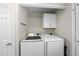 Laundry room featuring a modern washer and dryer with storage cabinets above at 323 Brandermill Dr, Durham, NC 27713