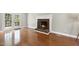 Bright living room features a brick fireplace, hardwood floors, and an adjacent set of French doors at 323 Brandermill Dr, Durham, NC 27713