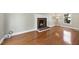 Open living room featuring hardwood floors, a cozy fireplace, and natural light from a nearby window at 323 Brandermill Dr, Durham, NC 27713