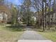 Winding pathway through a residential neighborhood, lined with trees and leading towards inviting homes at 323 Brandermill Dr, Durham, NC 27713