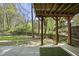 Concrete patio overlooking a beautiful, wooded backyard, partially covered and offering shade at 323 Brandermill Dr, Durham, NC 27713